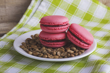 Pink macarons on a plate with green coffee