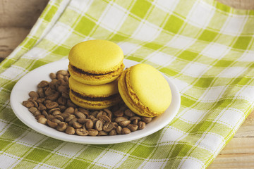Yellow macarons on a plate with green coffee