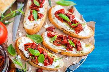 Bruschetta with cream cheese, pesto, fresh basil and sun dried tomatoes