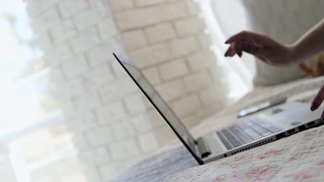 The girl with beautiful manicure opened the laptop. The girl started something printing quickly on the keyboard. In slow motion