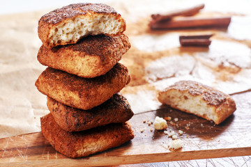 Close-up of tower of cinnamon cookies with one bitten biscuit on baking paper. 
