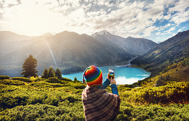Tourist woman in rainbow hat at the mountains