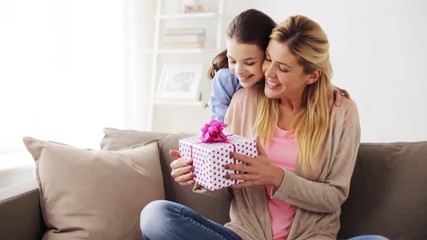happy girl giving present to mother at home