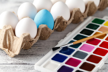 easter, holidays, tradition concept - close up of coloring easter eggs with colors and brush