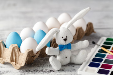 Fluffy rabbit in basket with Easter eggs