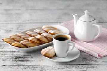 Homemade vanilla cookies Madeleine with a cup of coffee on a wooden background. Holidays food.
