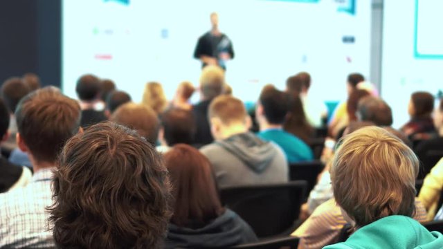 Listening to the speech about marketing and management of company for successful sales. Speaker gives a lecture to spectators and listeners.