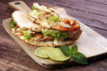 Delicious kebab sandwiches on wooden table