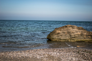 Fototapeta na wymiar Sea shoreline . Stone rock on the sea background