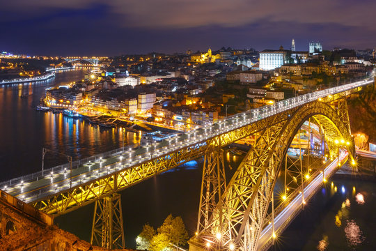 Picturesque aerial view of Old town of Porto, Ribeira and Dom Luis I or Luiz I iron bridge across Douro River at night, Portugal