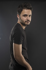Fototapeta na wymiar Caucasian guy wearing black T-shirt in studio 