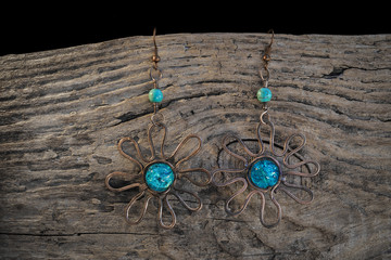 Copper earrings with blue turquoise on wodden board