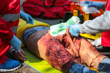 Doctors of emergency care, issuing of first aid to victim of a terrorist attack, an explosion, damage to both legs with heavy bleeding