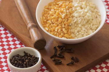 Brazilian dessert sweet canjica of yellow and white dry corn with clove in bowl and towel. Festa Junina Party Brazilian Culture Concept Image. 