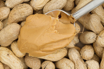Peanut butter and raw peanuts in shells