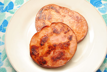 Two Fried Ham Steaks Served on a White Plate