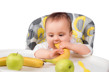 Fototapeta premium little child girl sitting at table with fruits isolated
