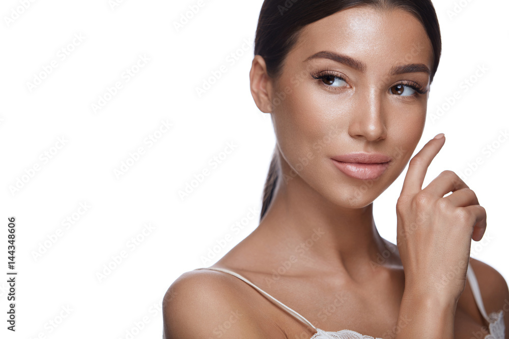 Wall mural young woman with smooth soft skin touching face. skin care