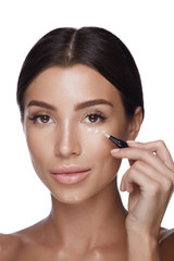 Fototapeta premium Cosmetics. Beautiful Woman Applying Concealer On Skin Under Eyes