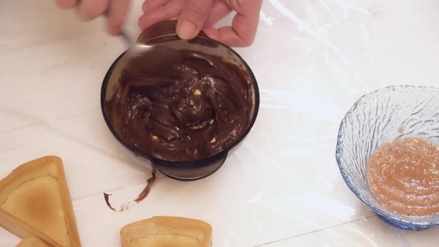 Woman's hands stirring the chokolate in the bowl with the spoon