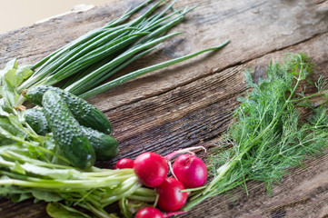 fresh vegetables, radishes, dill, cucumber, onion, cabbage on a wooden background