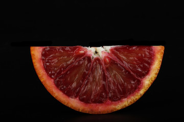 blood red orange slice isolated on black background