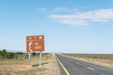 Road sign with emergency numbers
