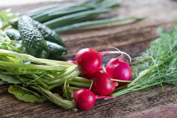 fresh vegetables, radishes, dill, cucumber, onion, cabbage on a wooden background