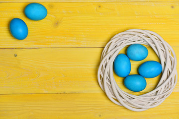 traditional eggs painted in blue color inside woven wooden wreath