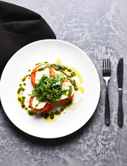 Tasty tomatoes sliced with mozarella cheese and green arugula salad