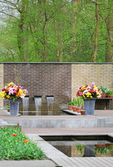 The fountain with flowing water and flowerbeds