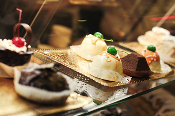 shelf at a bakery with pastries and cakes,Modern bakery with different cakes,Closeup of cake and biscuits in display cabinet at coffee shop,cakes in the shop window