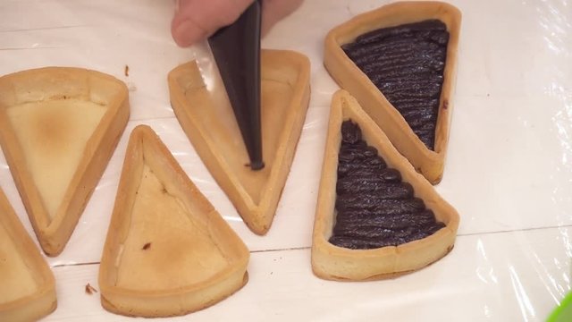 Adding chokolate to the small tarts closeup
