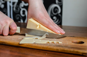 Slicing cheese on a wooden board.