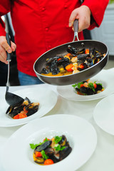 The process of cooking the mussels in a dripping pan and serving on a plate