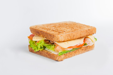 Close up sandwich with salmon, fresh tomatoes and cucumber, cheese and lettuce with toasted bread. Isolated on the white background, selective focus