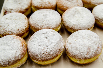 Donuts sprinkled with powdered sugar.