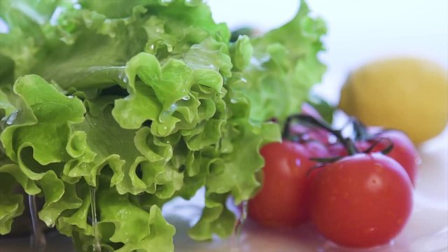 Fresh lettuce salad falls under water with a splash. Super slow motion