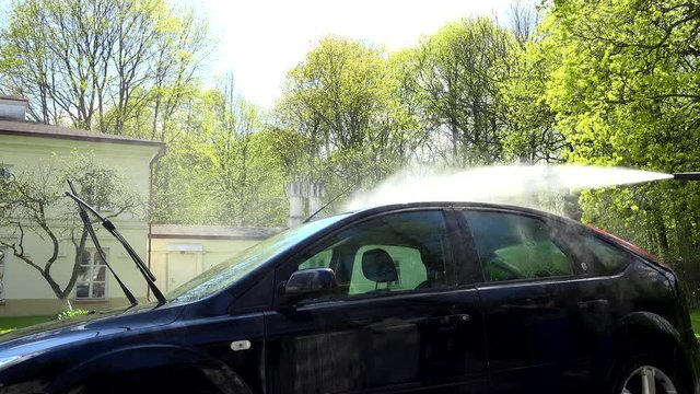 washing car with using a high pressure water jet.