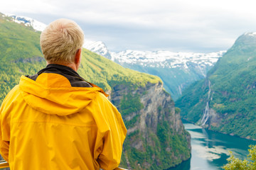 Tourist looking at Geirangerfjord from Flydasjuvet viewpoint Norway