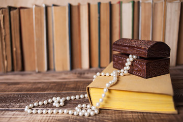 Books on the wooden table, bead casket on the book