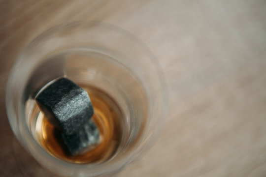 Stones for cooling whiskey and glases tulup on light wooden background