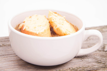 Onion soup with toast on a wooden background