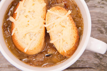 Onion soup with toast on a wooden background