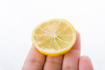 hand with slice of lemon fruit isolated on white background