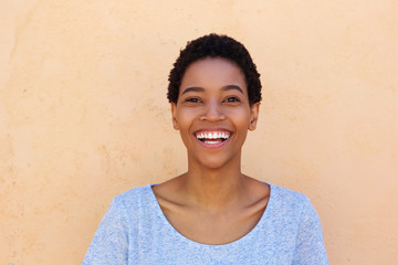 young african american woman smiling against orange wall