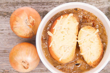 Onion soup with toast on a wooden background