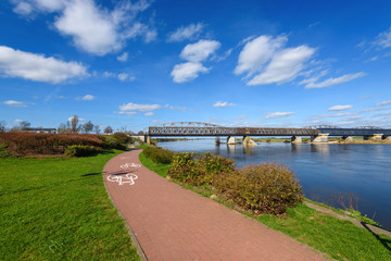 Vistula riverbank promenade in Tczew. The historic bridge in background. Poland.