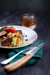 Tagliata of beef with salad on a white plate