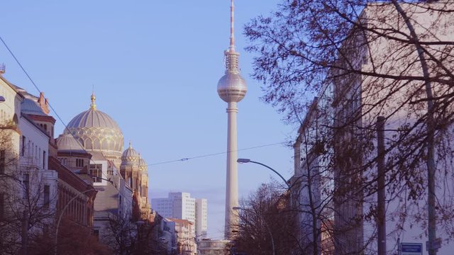 Street view of the synagogue and the Berlin TV tower, On the left side of the picture is the synagogue the sunlight reflected golden. The television tower (Fernsehturm) appears to be at the end.